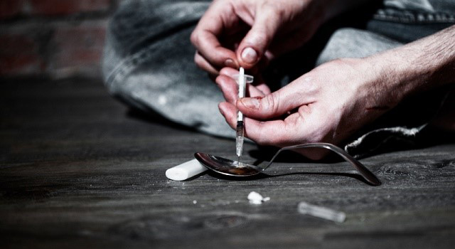 man's hands shooting heroin 